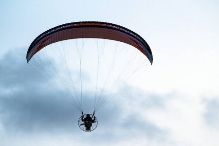 一个人正驾驶滑翔伞飞过大海和海滩