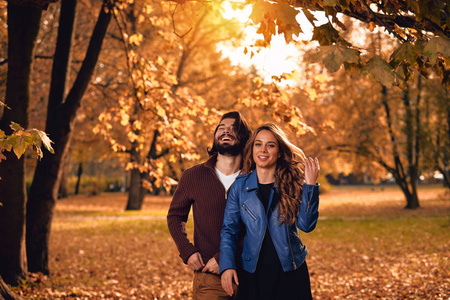情侣在秋天的季节彩色公园享受户外。