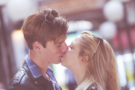 可爱的年轻夫妇在街上亲吻。