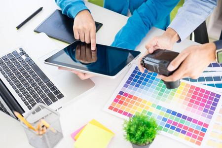 创意或室内设计师团队合作，与Pantone样本和建筑计划在办公桌面建筑师选择颜色样本的设计项目在台式计算机和选择使用一些彩色样本
