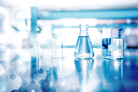 具有纳米化学分子结构的蓝色背景的眼镜实验和教育实验室用烧瓶烧杯瓶玻璃器皿