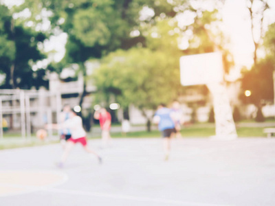 亚洲儿童在温暖阳光下打篮球的模糊照片