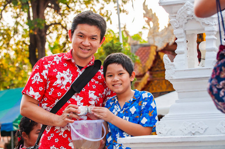 泰国家庭在泰国北部清迈的松克兰节期间在寺庙里参加古老的传统活动，泰国非常著名的活动