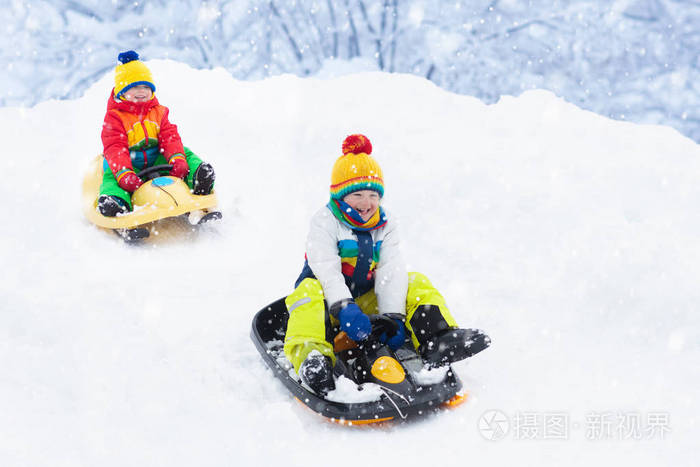 坐雪橇的小男孩儿童雪橇幼儿骑雪橇孩子们在雪地里户外玩耍孩子们冬天