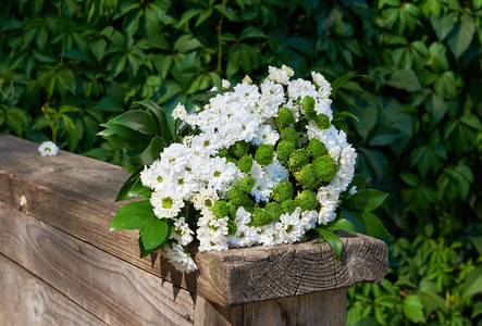 五颜六色的花朵组成花束白色装饰雏菊躺在天然的旧木板上