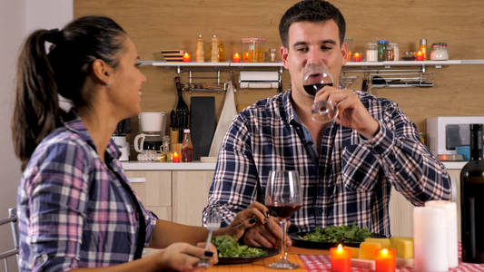 美丽的年轻夫妇享受一些红酒, 而有一个浪漫的晚餐