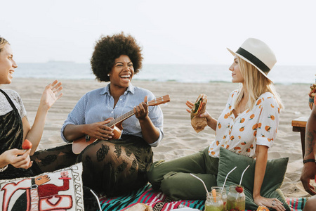 朋友们一起在海滩野餐时唱歌图片