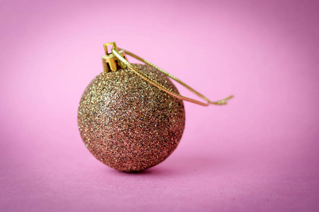 金黄小圆形玻璃塑料冬天聪明闪亮的装饰美丽的圣诞节圣诞球, 圣诞玩具贴上在紫色粉红色的背景上的小圆形圣诞球
