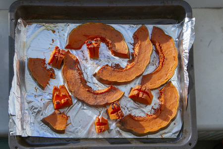 烤南瓜在调味的甲板上的箔片图片