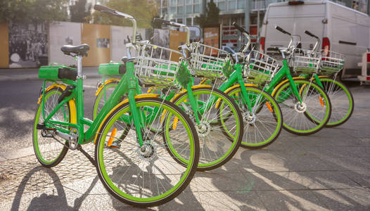 绿色租赁自行车与篮子停在鹅卵石街道柏林德国壁纸。