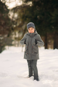 冬天的天气里, 一个小男孩在公园里散步, 玩雪球和高兴。等待圣诞节的心情