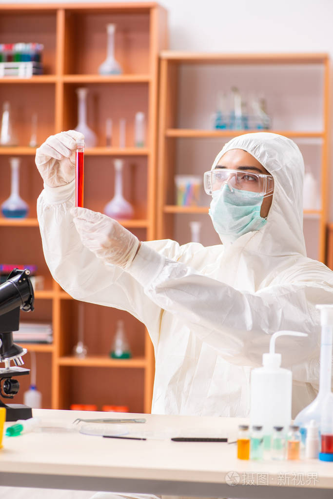 在实验室里穿着防护服工作的年轻生物化学家