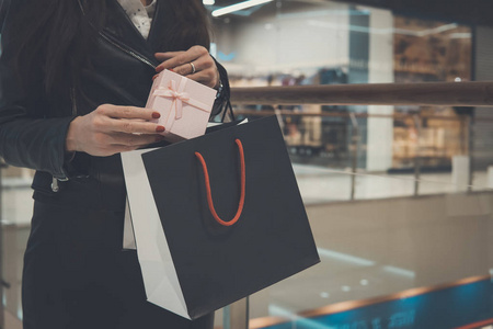 s shopping. Woman puts a gift box in a black package