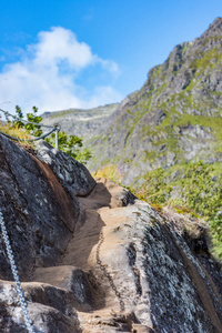 在令人叹为观止的山脉和挪威洛夫顿群岛的尖锐绿色山峰上的石质小径上徒步旅行。