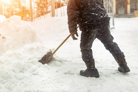 人在大雪后把雪从人行道上移走。 冬天的暴风雪和暴风雪。 防止滑溜。