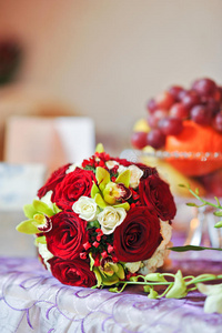 桌上摆着一束美丽的玫瑰花。婚礼上的一束红玫瑰。餐厅餐桌上摆着优雅的婚礼花束