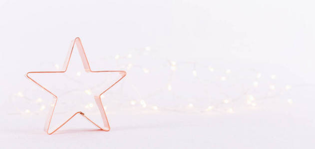 明星铜饼干切割机在白色闪闪发光的背景与Bokeh灯。 节日圣诞节和新年背景。 横宽屏幕横幅格式