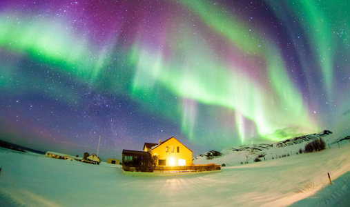 北极光或更著名的北极光在冰岛雷克雅未克冬季的背景视图