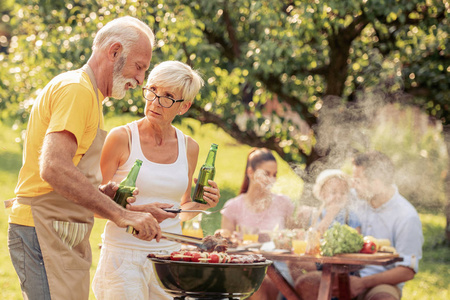 家庭时间。一家人在度假，在他们的花园里举行烧烤聚会。
