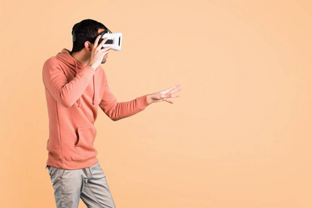 穿着粉红色运动衫的人用VR眼镜。 Ocher背景下的虚拟现实体验