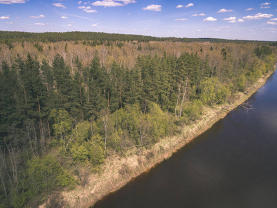 无人机图像。 多云春日农村地区田野森林和河流水反射的鸟瞰图。 拉脱维亚老式老电影