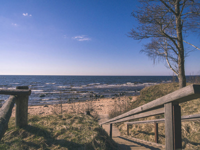 无人机图像。 波罗的海岩石海滩乡村地区的鸟瞰图。 遥远的地平线平静的一天，老式的老电影看着