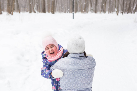 家庭, 童年和自然概念年轻的母亲拥抱小女儿在冬季公园