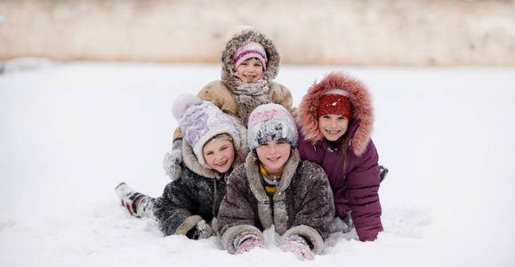 有趣的孩子们在雪地冬季公园玩耍和欢笑，快乐的姐妹
