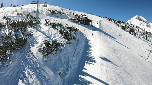 滑雪缆车，座位经过山上，可以看到人们在斜坡上滑雪和滑雪板