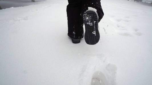 冬天在森林里深雪行走的女人的腿