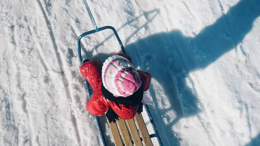 在冬季的生活方式跟踪拍摄中，小女孩在公园的雪地里滑雪