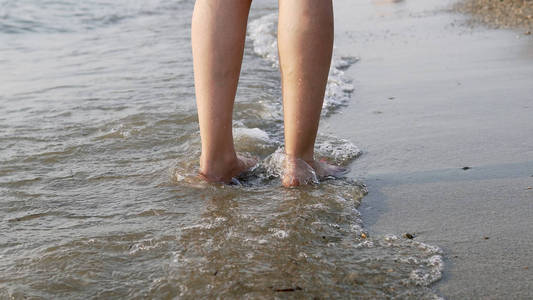 跟着一只赤脚的女性脚走，溅在海水上，电影稳定镜头