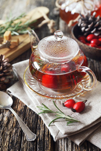 健康的冬季热饮料。 茶壶迷迭香和浆果中的玫瑰红茶