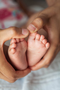 s feet in the mother hands. Baby. Cozy. Family.