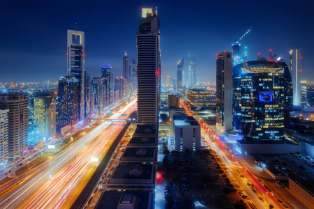 美丽的鸟瞰迪拜市中心城市中心灯天际线在夜间阿拉伯联合酋长国。 长曝光光迹效应