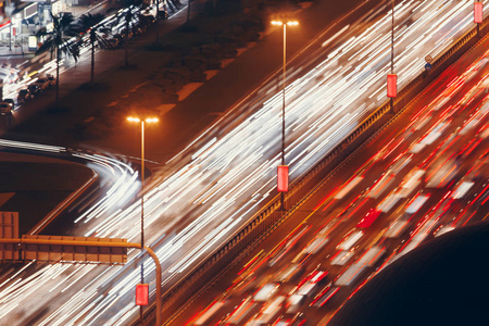 道路背景上的汽车。 高速公路交通。 夜间光线跟踪效应