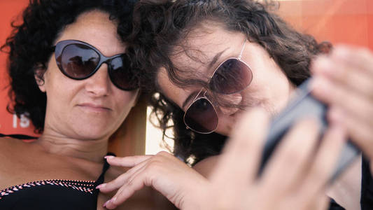 母亲和女儿在暑假期间制作智能手机自拍，电影选择性聚焦