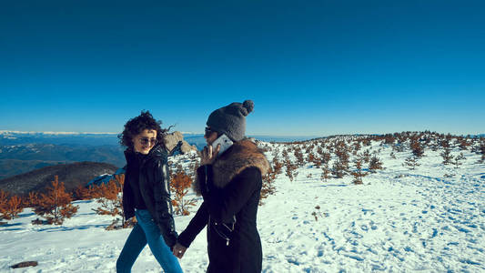 两个美丽的快乐少年微笑着走在冬天的雪地上