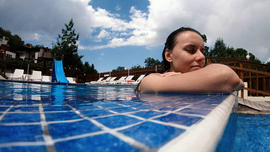 一个的少女在夏日的豪华泳池里尽情放松