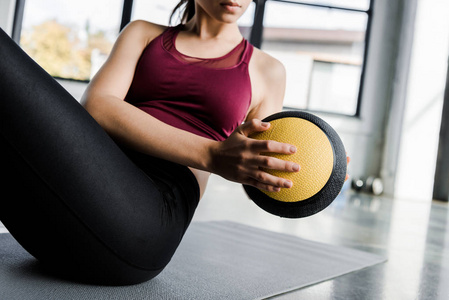 女运动员在体育中心用药球做腹肌运动