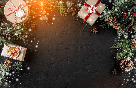 圣诞礼品盒在节日背景与杉树枝松果。 圣诞节和新年快乐主题博凯赫闪闪发光。 平躺顶部视图空间文本