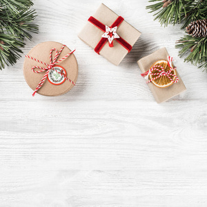 圣诞礼品盒白色木制背景与冷杉枝松果。 圣诞节和新年快乐主题。 平躺顶部视图空间文本