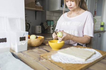 快乐的女人正在家里的厨房里准备一个馅饼。幸福家庭和家庭舒适的概念