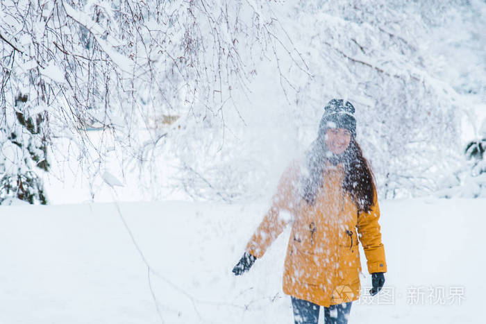 一个女人在下雪的城市公园里玩概念