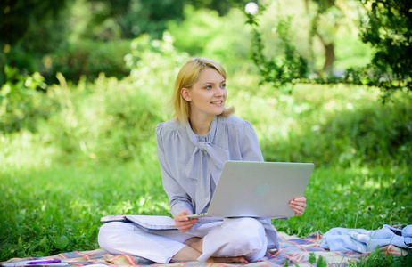 商务女士自由职业者在户外工作。成为成功的自由职业者。拿着笔记本电脑的女人坐在地毯草地上。在线自由职业者的职业理念。愉快的职业。指