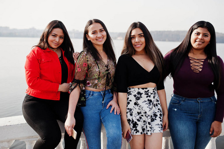 来自厄瓜多尔的四个快乐漂亮的拉丁女孩组成的小组对抗湖边。