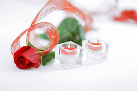 红玫瑰和一对白色背景蜡烛. 照片与