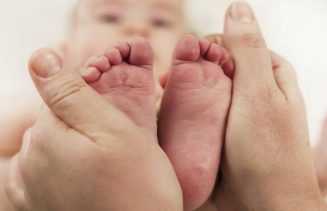 父母抱着新生婴儿的双手脚。