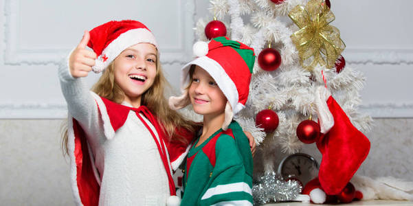 家庭度假传统。孩子们欢庆圣诞节。孩子们穿着圣诞老人和精灵的服装。冬季化装舞会的概念。兄弟姐妹们准备庆祝圣诞节或迎接新年。圣诞快乐