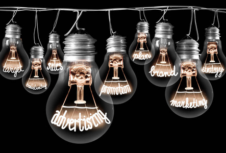 灯泡与发光纤维的照片，广告概念相关的单词隔离在黑色背景上